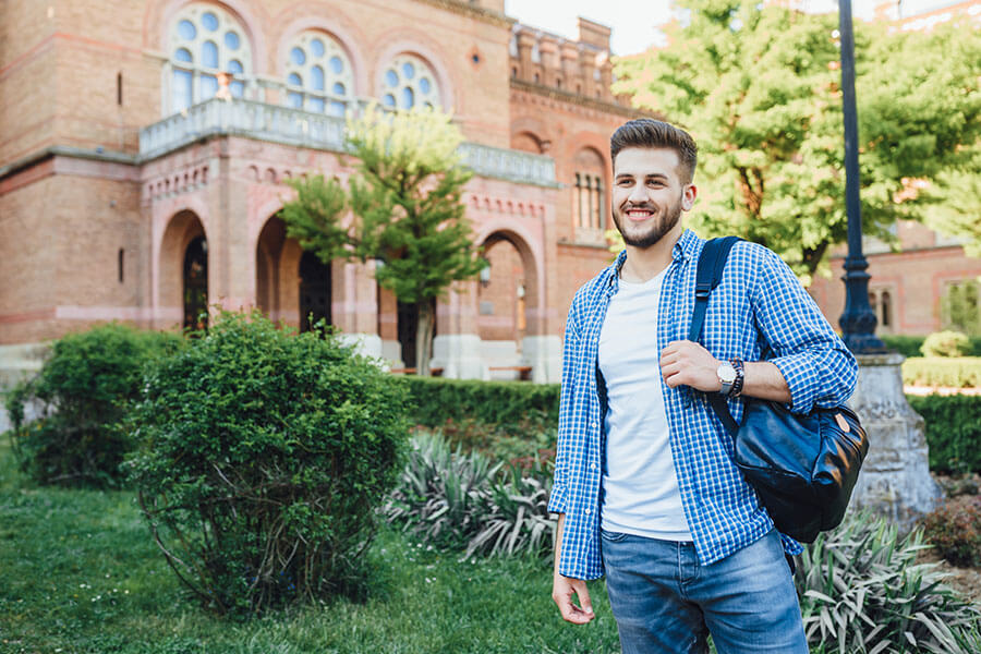 College student smiling because his personal line of credit helped cover extra expenses this semester.
