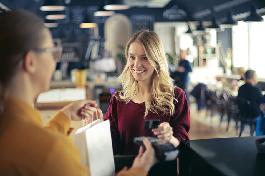 A woman uses her credit union credit card to pay for a food order.