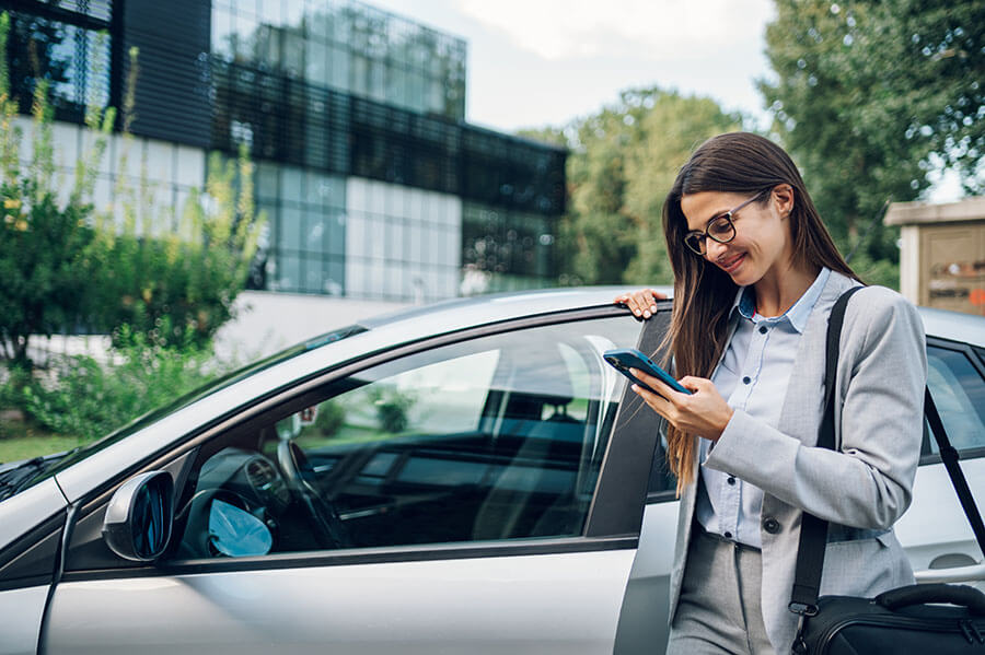 Business woman standing next to her car