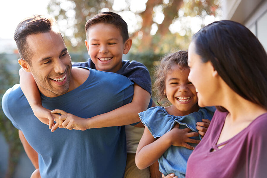 Happy family with two kids smiling at each other, symbolizing financial flexibility and support from a personal line of credit.