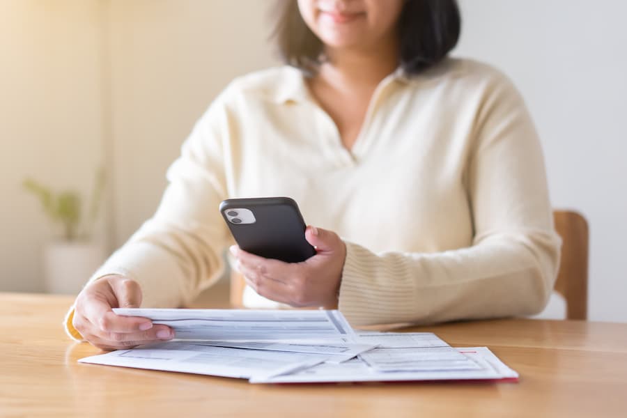 Woman paying bills using the Freedom CU app on her mobile phone.